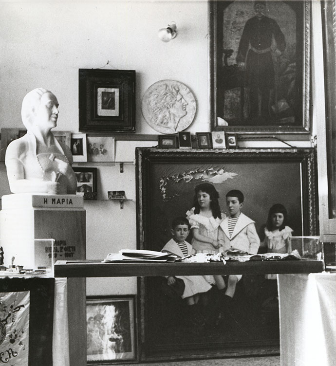 Αντικείμενα από τον πρώτο εκθεσιακό χώρο, στην οικία του Ν. Φίστα στο Νυμφαίο. Στη φωτογραφία διακρίνεται η προτομή της γυναίκας του, Μαρίας, και πίνακες από το αρχοντικό του Μίχα Τσίρλη. Δεκ. 1960-1970.